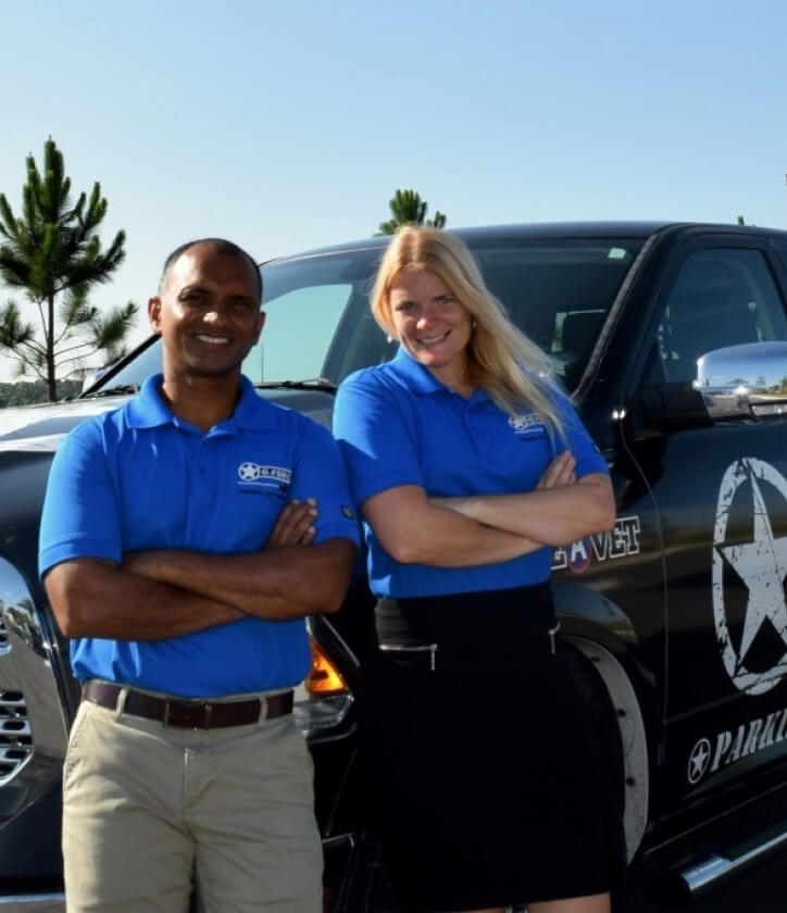 two g-force employees posing in front of truck